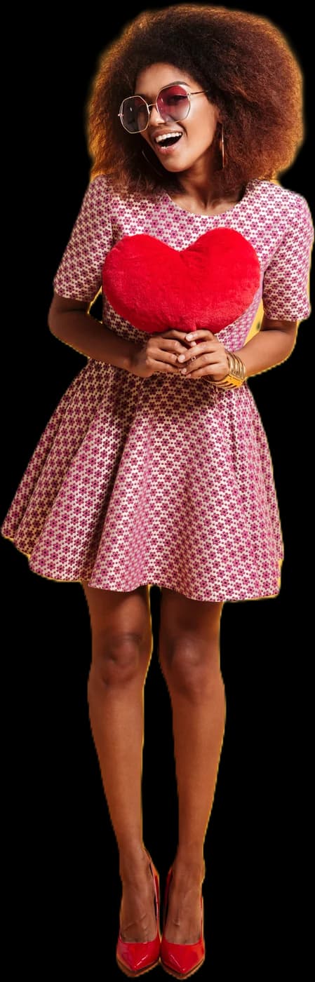 Jeune femme souriante en robe à motifs, serrant un cœur en peluche